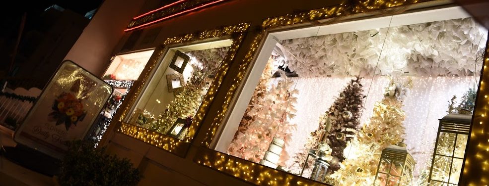 The front of a Christmas shop with two beautifully decorated window displays