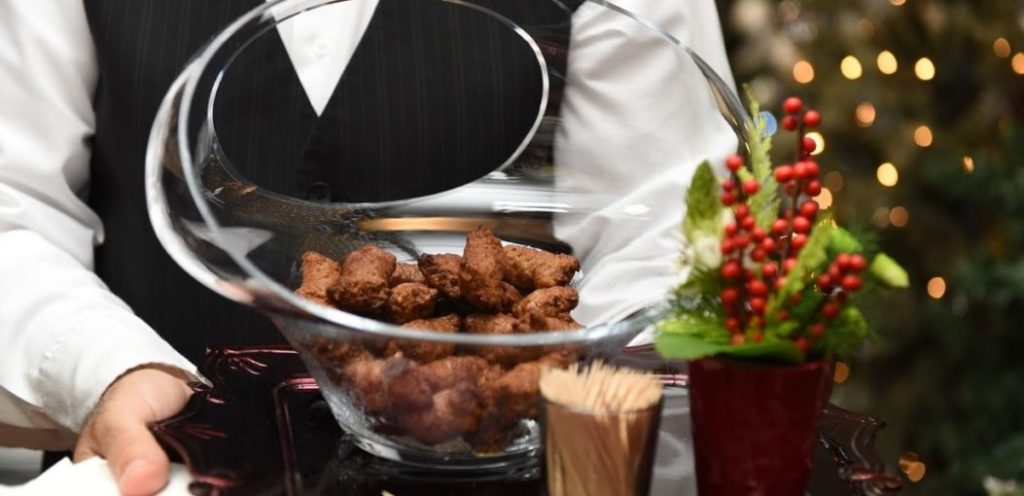 A waiter holding a tray with chicken bits