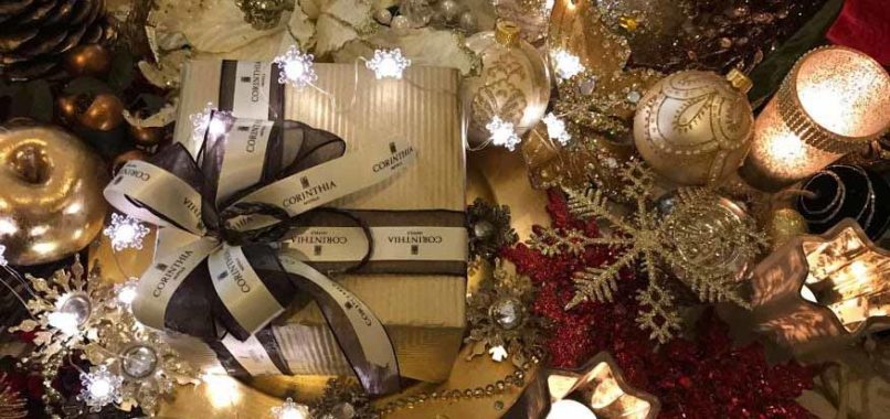 A wrapped gift surrounded by Christmas decor and lights
