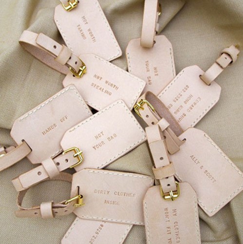 A handful of cream luggage tags with quotes written on them