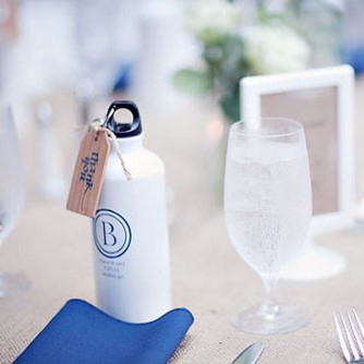 A metal bottle of water with a blue personalized message