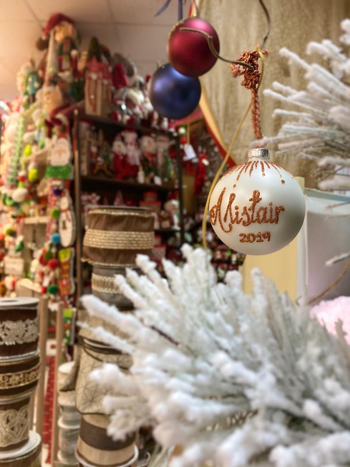 A white bauble with gold personalized text