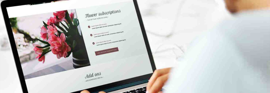 A person in front of a laptop with the window saying flower subscriptions