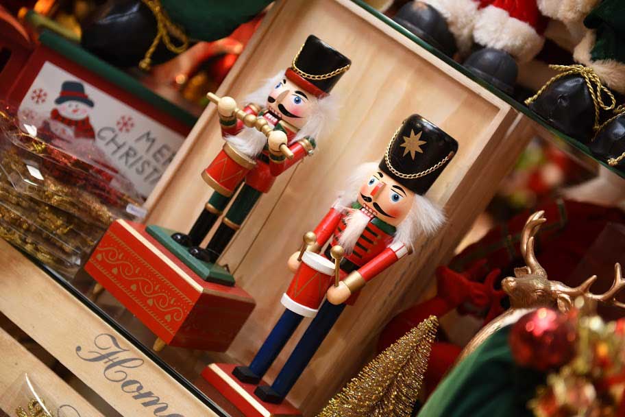 Two small nut crackers in red on a shelf of a Christmas shop.