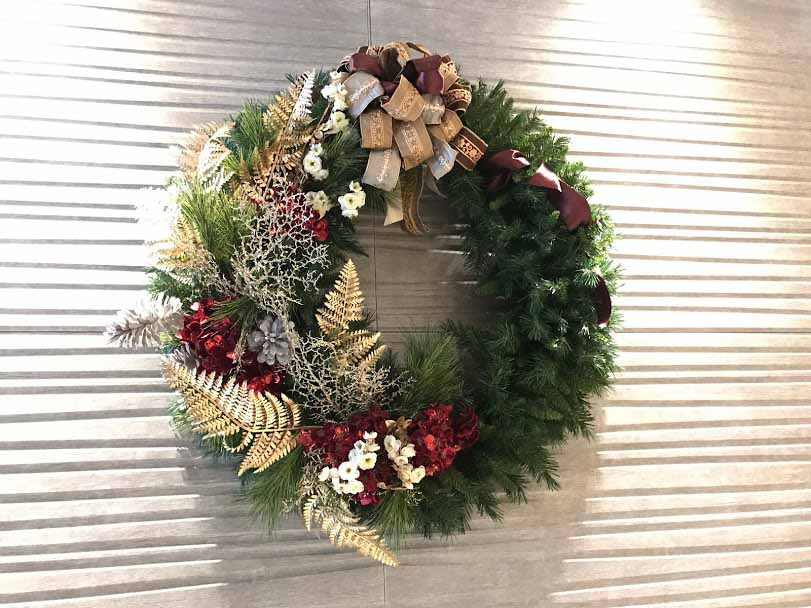 A semi decorated Christmas wreath with gold and silver foliage.