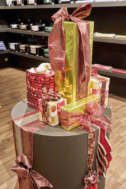 A centerpiece with gold and red Christmas gifts wrapped beautifully.